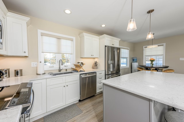 kitchen with recessed lighting, a sink, stainless steel appliances, white cabinetry, and light wood-type flooring