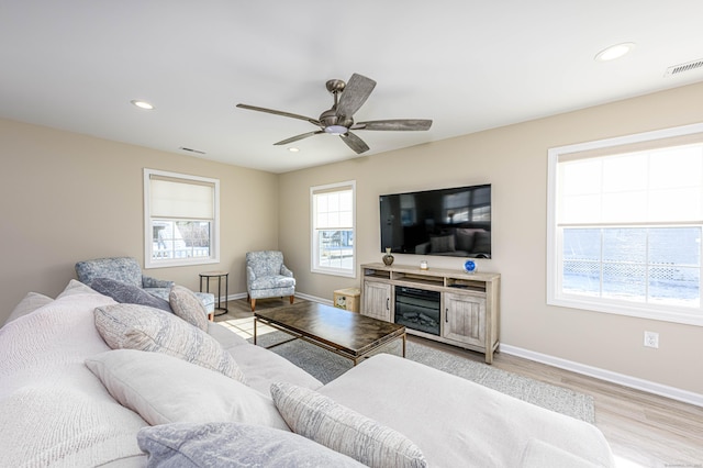 living area featuring light wood-type flooring, visible vents, baseboards, and recessed lighting