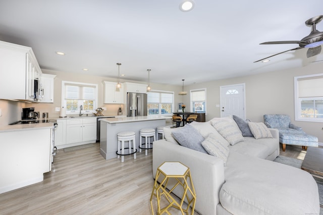 living area featuring recessed lighting, light wood-style floors, and ceiling fan