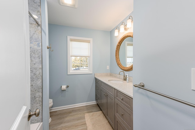 full bath with visible vents, toilet, wood finished floors, baseboards, and vanity