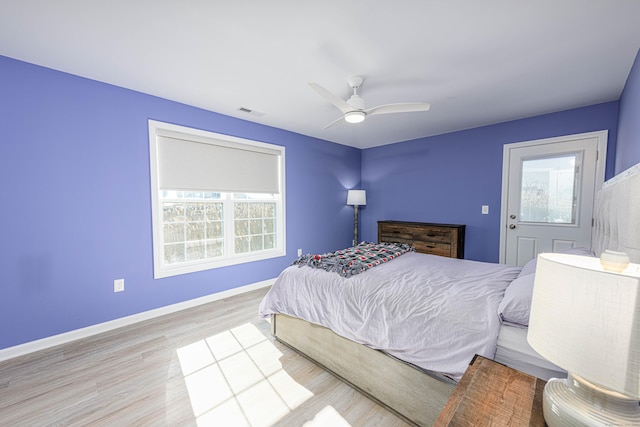 bedroom with visible vents, baseboards, wood finished floors, and a ceiling fan