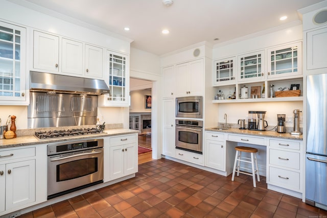 kitchen featuring under cabinet range hood, a sink, recessed lighting, stainless steel appliances, and white cabinets