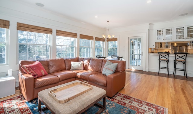 living room with recessed lighting, light wood finished floors, and a chandelier