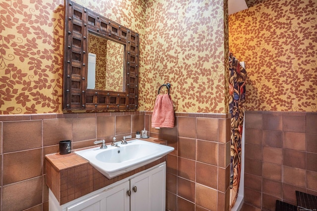 bathroom featuring wainscoting, wallpapered walls, and vanity