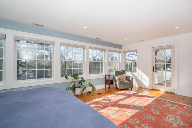 bedroom featuring wood finished floors, visible vents, baseboards, recessed lighting, and access to exterior