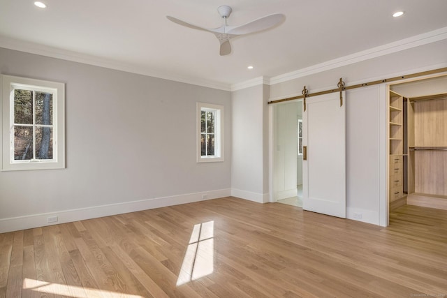 412 Tanner Marsh Rd, Guilford, CT 06437 - unfurnished bedroom featuring a barn door, crown molding, baseboards, light wood-style floors, and recessed lighting