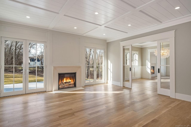412 Tanner Marsh Rd, Guilford, CT 06437 - unfurnished living room with a lit fireplace, french doors, plenty of natural light, light wood finished floors, and wooden ceiling