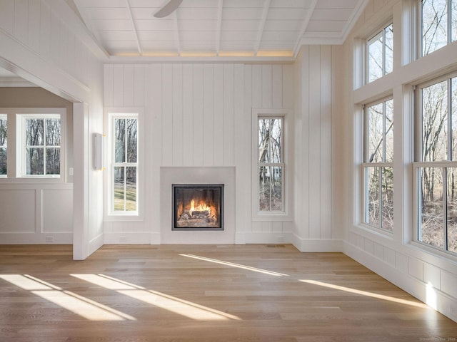 412 Tanner Marsh Rd, Guilford, CT 06437 - unfurnished living room featuring wood finished floors, a glass covered fireplace, a decorative wall, and a ceiling fan