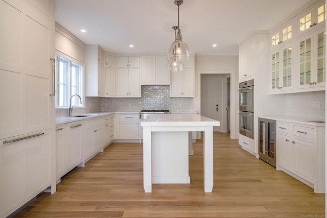 412 Tanner Marsh Rd, Guilford, CT 06437 - kitchen with a sink, beverage cooler, stainless steel appliances, white cabinets, and backsplash