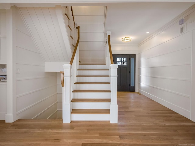 412 Tanner Marsh Rd, Guilford, CT 06437 - stairway featuring wood finished floors, a decorative wall, and crown molding