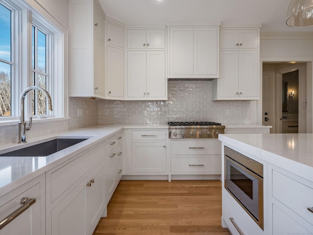 412 Tanner Marsh Rd, Guilford, CT 06437 - kitchen with stainless steel appliances, white cabinets, and decorative backsplash
