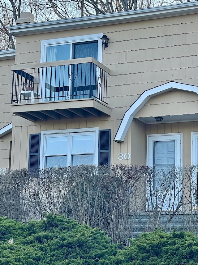 entrance to property with a balcony and a chimney