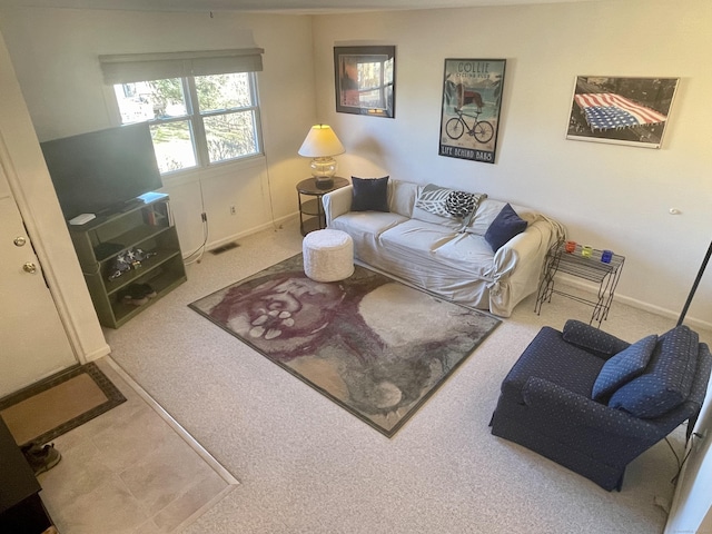 carpeted living area featuring visible vents and baseboards