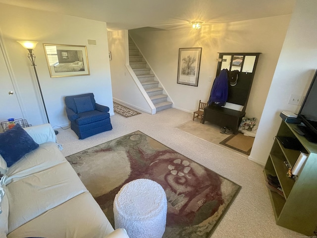 carpeted living area featuring baseboards and stairs