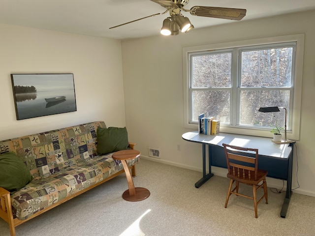 office space featuring visible vents, baseboards, light colored carpet, and a ceiling fan