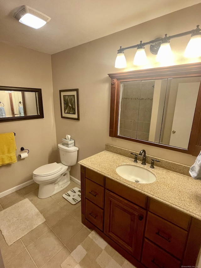 bathroom with baseboards, toilet, vanity, and tile patterned flooring