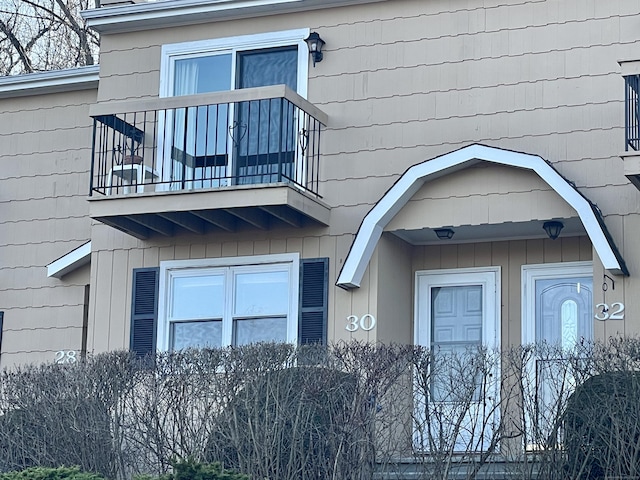 view of exterior entry with a balcony