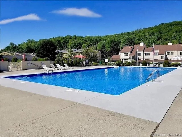 community pool featuring a patio and fence