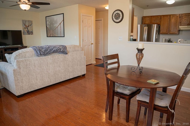 dining space with a ceiling fan and wood finished floors