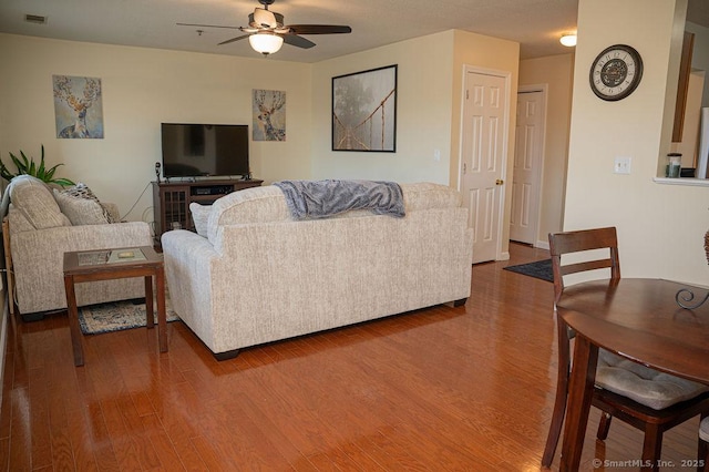 living area featuring wood finished floors, visible vents, and ceiling fan