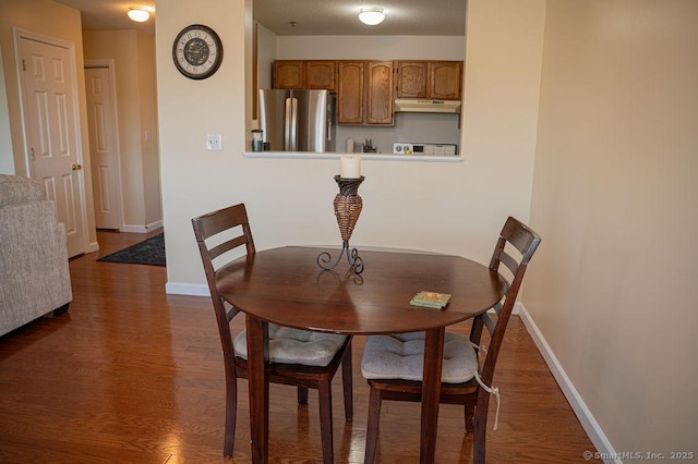 dining space with dark wood-style floors and baseboards