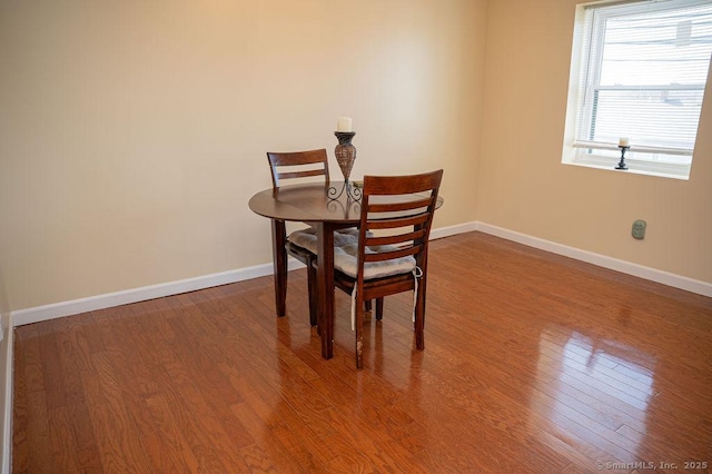 dining room featuring baseboards and wood finished floors