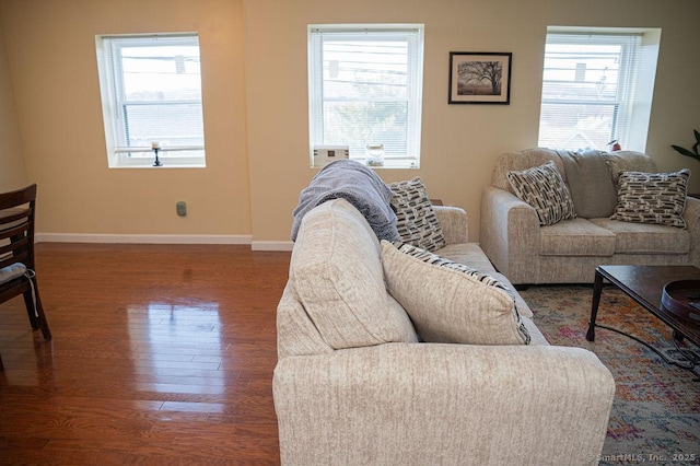 living area with plenty of natural light, wood finished floors, and baseboards