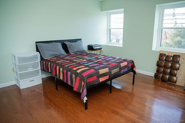 bedroom featuring baseboards and wood finished floors