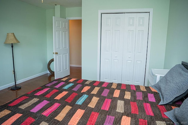 bedroom featuring a closet, baseboards, and wood finished floors