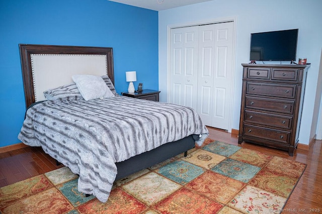 bedroom featuring a closet, baseboards, and wood finished floors