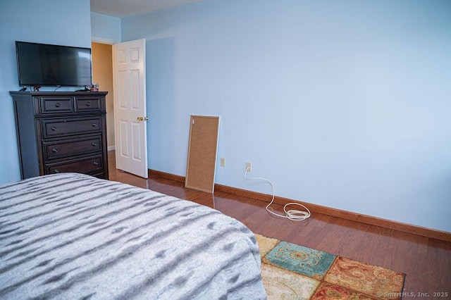 bedroom featuring wood finished floors and baseboards