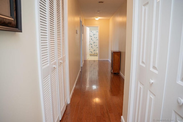 hall featuring baseboards and wood-type flooring