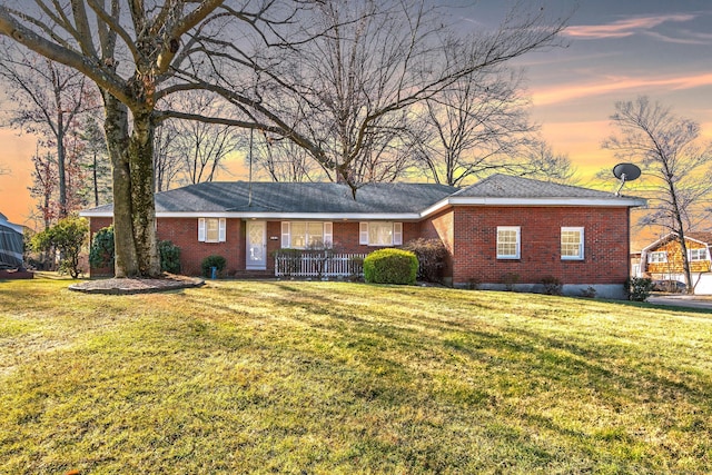 single story home with a front lawn and brick siding