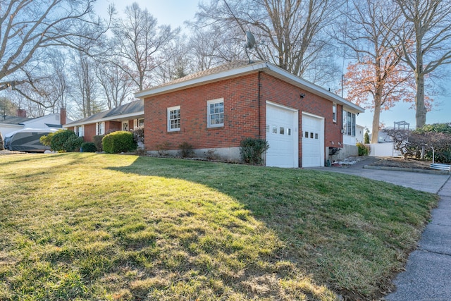 view of side of home featuring driveway, brick siding, an attached garage, and a lawn