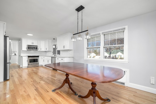 dining room featuring visible vents, baseboards, and light wood-type flooring