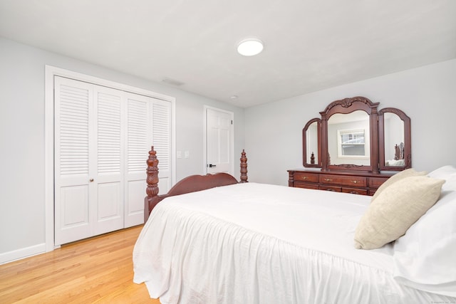 bedroom with a closet, visible vents, and light wood-type flooring