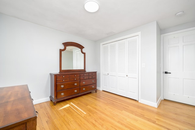 bedroom featuring a closet, baseboards, and light wood-style floors