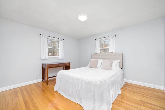 bedroom with light wood-style flooring and baseboards