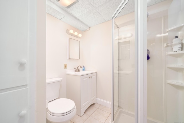 full bathroom featuring tile patterned floors, a stall shower, toilet, and a paneled ceiling