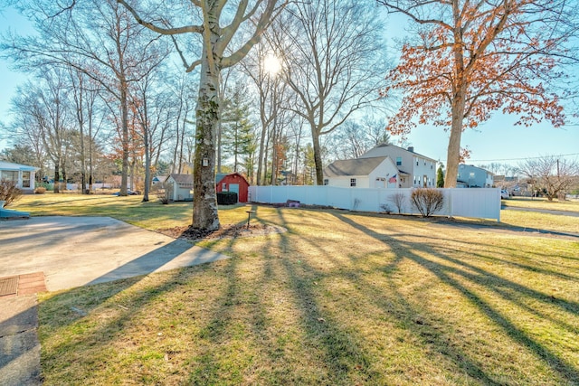 view of yard with an outbuilding, a storage shed, and fence