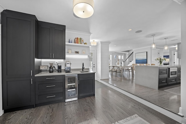 bar featuring crown molding, wine cooler, dark wood finished floors, stairs, and a sink