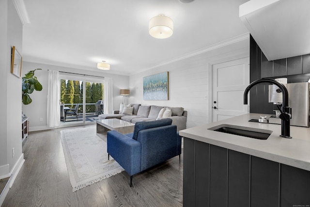 living area with dark wood finished floors, baseboards, and ornamental molding