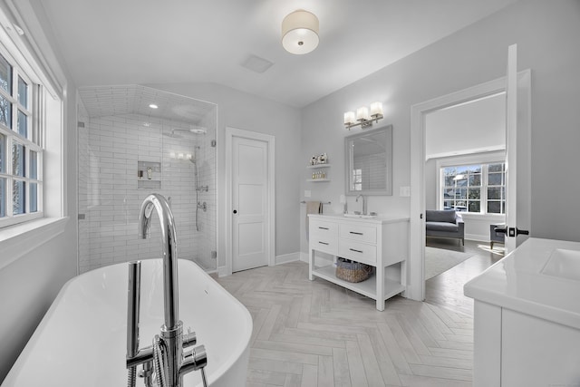 bathroom featuring vanity, baseboards, visible vents, a freestanding bath, and a shower stall