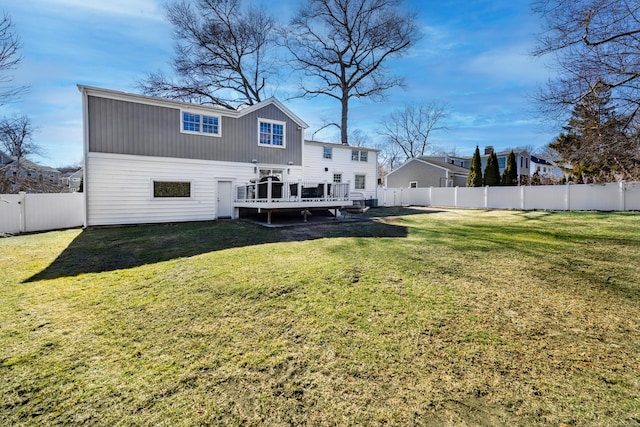 rear view of property with a deck, a fenced backyard, and a lawn