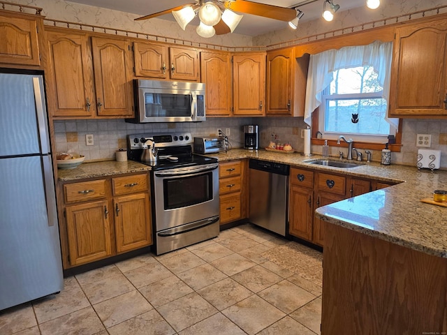 kitchen with a sink, decorative backsplash, brown cabinets, and appliances with stainless steel finishes