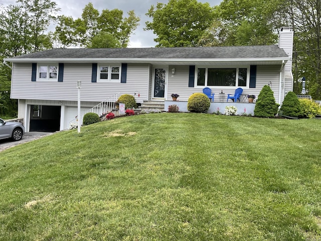 ranch-style house featuring an attached garage, a front lawn, entry steps, a chimney, and driveway