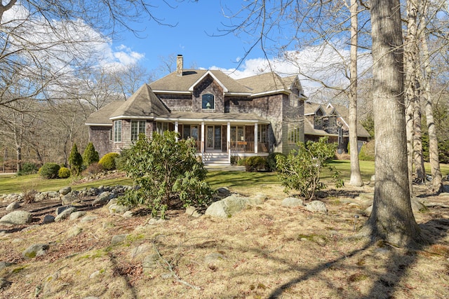 exterior space with a front yard, a porch, and a chimney