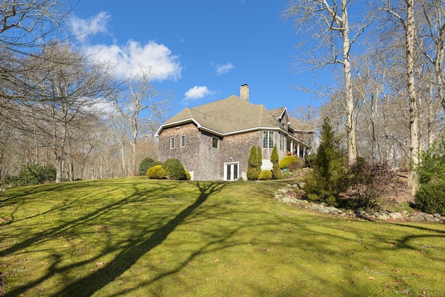 view of property exterior with a lawn and a chimney