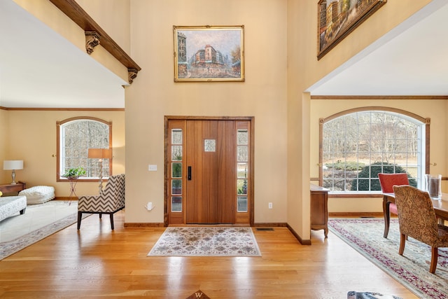 foyer with light wood-style flooring, plenty of natural light, and baseboards