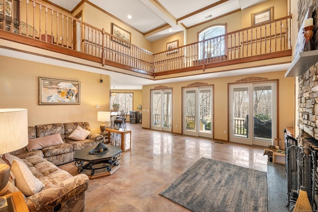 living area featuring baseboards, beam ceiling, a fireplace, and tile patterned flooring